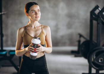 Creatine benefits shown with creatine monohydrate powder scoop next to dumbbells and healthy foods